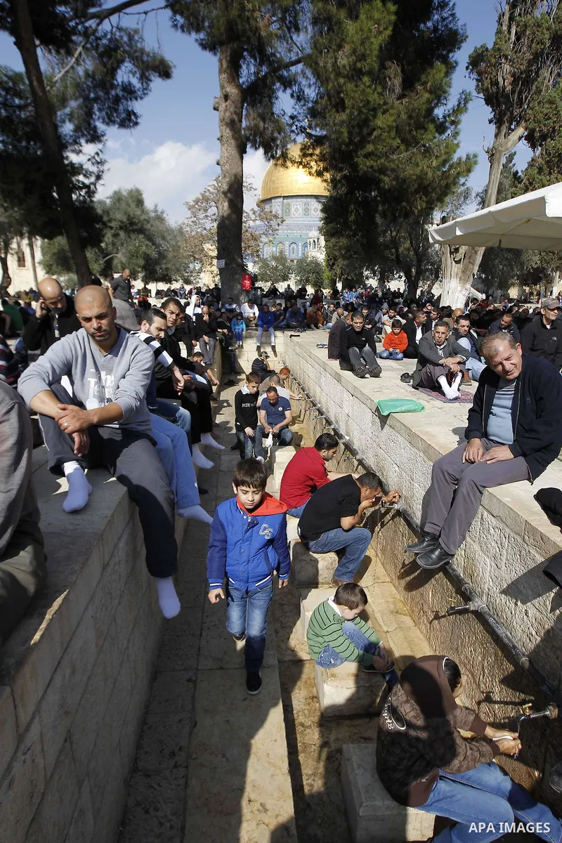Palestinian worshippers take part in Friday prayers outside the Dome of the Rock at the Al-Aqsa mosque compound in the Old City of Jerusalem on November 21, 2014. Israel eased age restrictions for Friday prayers at Jerus...