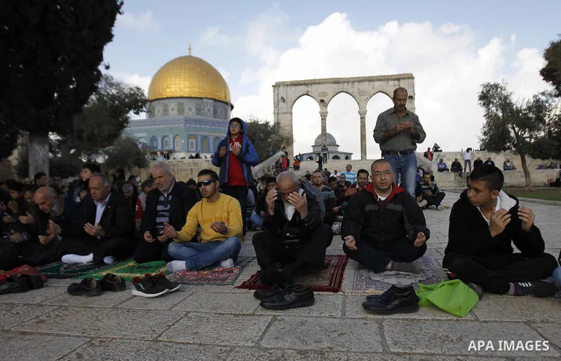 Palestinian worshippers take part in Friday prayers outside the Dome of the Rock at the Al-Aqsa mosque compound in the Old City of Jerusalem on November 21, 2014. Israel eased age restrictions for Friday prayers at Jerus...