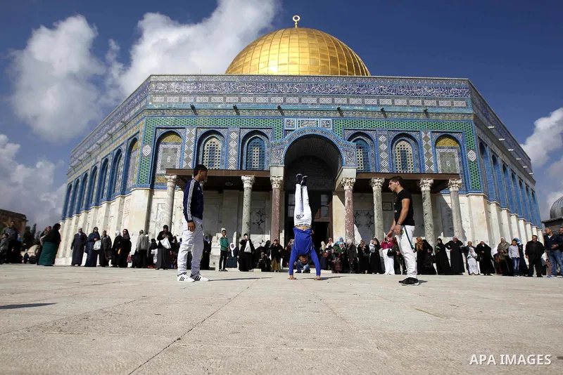 Palestinian youths practice parkour outside the Dome of the Rock mosque at the Al-Aqsa mosque compound following Friday prayers in the Old City of Jerusalem on November 21, 2014. Israel eased age restrictions for Friday...
