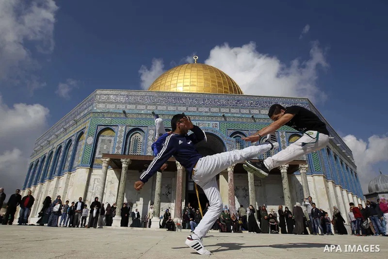 Palestinian youths practice parkour outside the Dome of the Rock mosque at the Al-Aqsa mosque compound following Friday prayers in the Old City of Jerusalem on November 21, 2014. Israel eased age restrictions for Friday...
