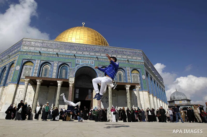 Palestinian youths practice parkour outside the Dome of the Rock mosque at the Al-Aqsa mosque compound following Friday prayers in the Old City of Jerusalem on November 21, 2014. Israel eased age restrictions for Friday...