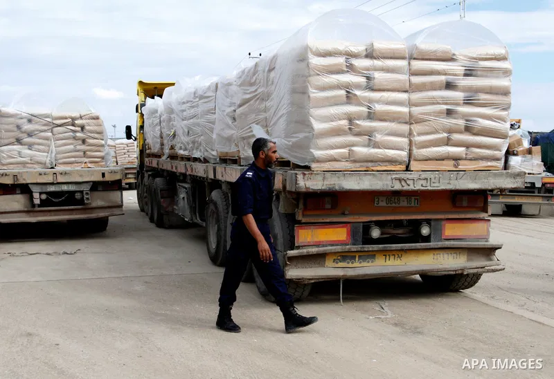 A Palestinian policeman walks past trucks loaded with cement that entered the Gaza Strip from Israel through the Kerem Shalom crossing in Rafah in the southern Gaza Strip on November 25, 2014. Twenty-eight trucks of ceme...