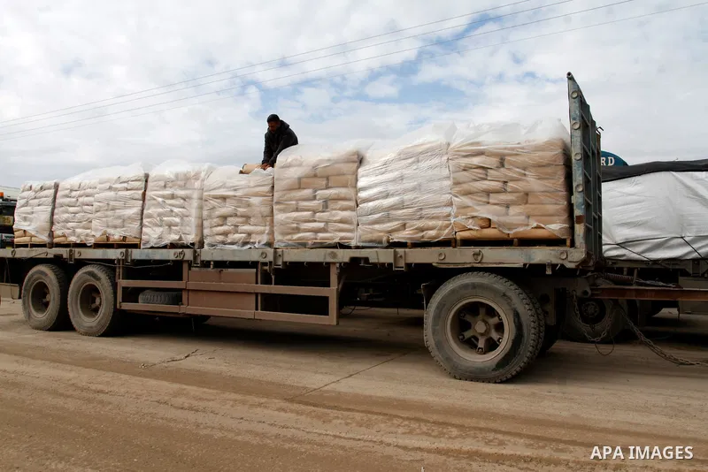 A Palestinian worker walks on top of bags of cement loaded on a truck that entered the Gaza Strip from Israel through the Kerem Shalom crossing in Rafah in the southern Gaza Strip on November 25, 2014. Twenty-eight truck...