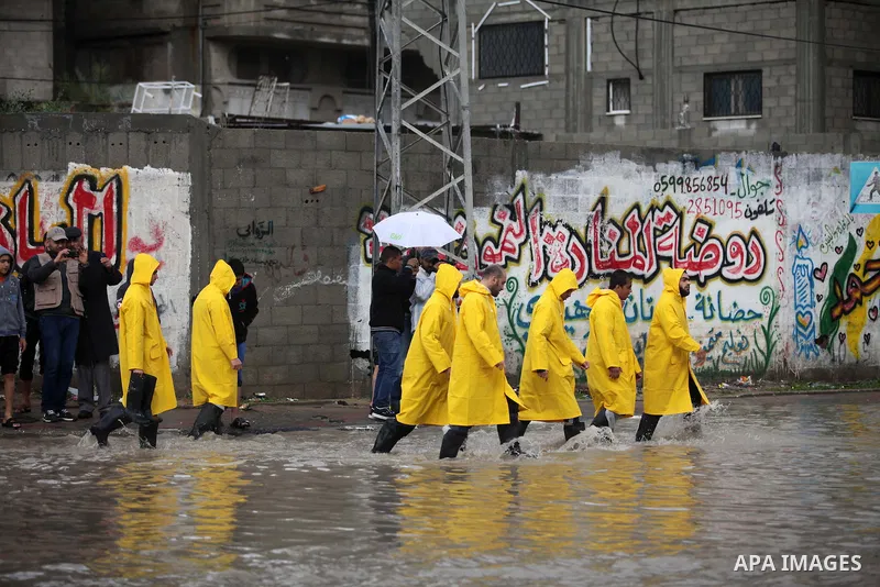 Palestinians of civil defence walk through a flooded road as they arrive to help people during heavy rain in Gaza City November 27, 2014. The civil defence asked residents in an area east of Gaza City to evacuate their h...