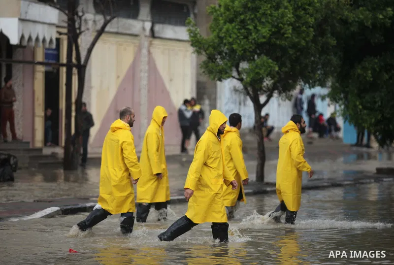 Palestinians of civil defence walk through a flooded road as they arrive to help people during heavy rain in Gaza City November 27, 2014. The civil defence asked residents in an area east of Gaza City to evacuate their h...