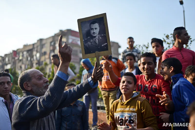 An Egyptian man holds a picture of former Egyptian leader Jamal Abdel Nasser during a rally to support the President Abdel Fattah al-Sisi, in Cairo on November 28, 2014. The planned Islamist protests that have been calle...