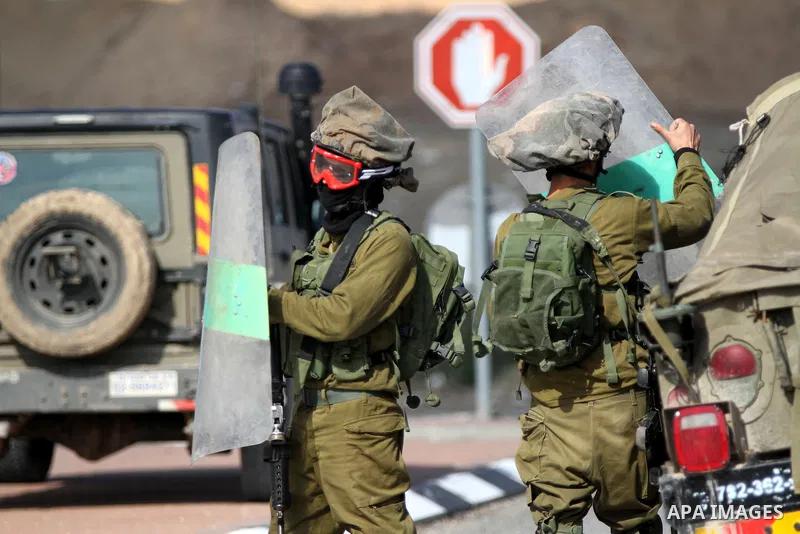 Israeli soldiers take position during clashes with Palestinian protesters as they try to block a highway between Jerusalem and the Dead Sea near the West Bank town of Jericho Friday, Nov. 28, 2014. Photo by Shadi Hatem