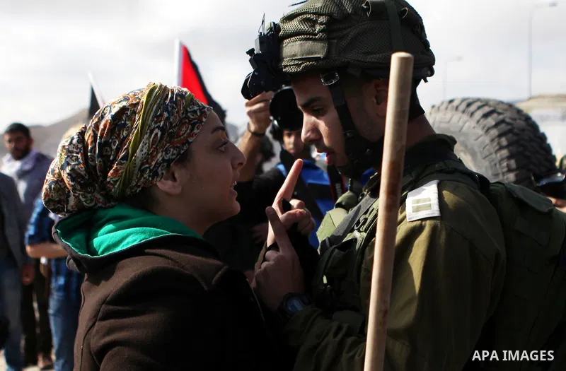 A Palestinian protester argues with an Israeli soldier as they try to block a highway between Jerusalem and the Dead Sea near the West Bank town of Jericho Friday, Nov. 28, 2014. Photo by Shadi Hatem