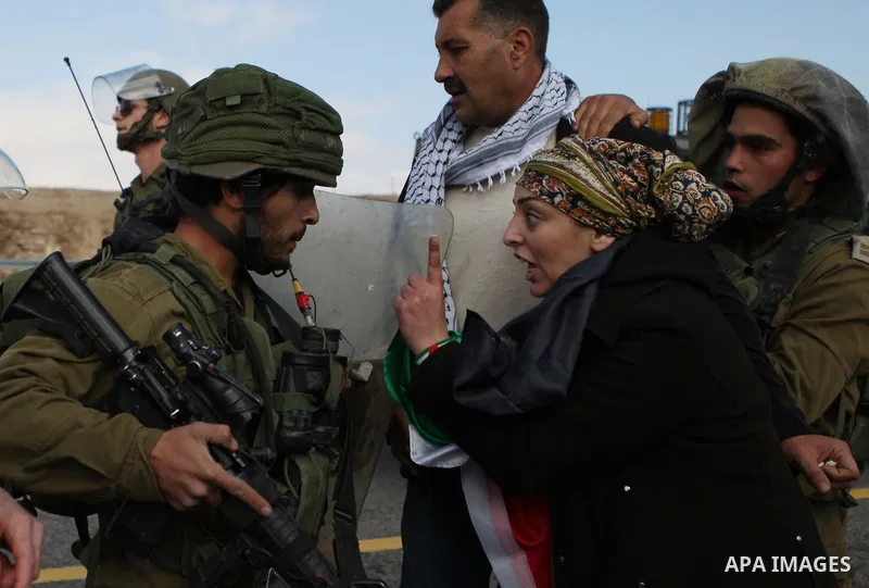 A Palestinian protester argues with an Israeli soldier as they try to block a highway between Jerusalem and the Dead Sea near the West Bank town of Jericho Friday, Nov. 28, 2014. Photo by Shadi Hatem