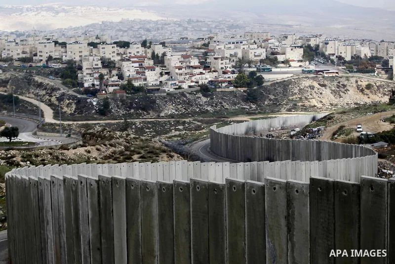 A general view shows the Palestinian Shuafat refugee camp behind Israel s controversial separation barrier in east Jerusalem on November 28, 2014. Israel has introduced a series of measures against the families of Palest...