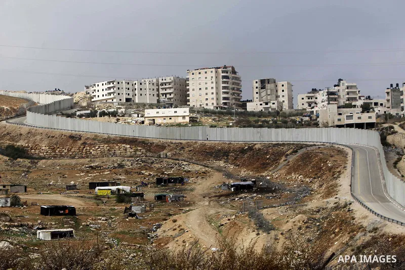A general view shows the Palestinian Shuafat refugee camp behind Israel s controversial separation barrier in east Jerusalem on November 28, 2014. Israel has introduced a series of measures against the families of Palest...