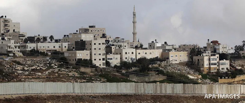 A general view shows the Palestinian Shuafat refugee camp behind Israel s controversial separation barrier in east Jerusalem on November 28, 2014. Israel has introduced a series of measures against the families of Palest...