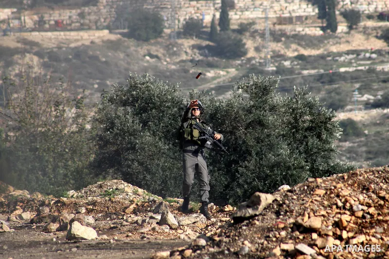 A member of Israeli security forces throws a tear gas canister at Palestinian protesters during clashes in a protest against the expropriation of Palestinian land by Israel following Friday prayers in the village of Kafr...