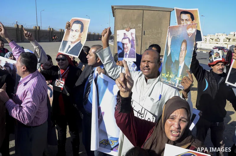 Supporters of former Egyptian President Hosni Mubarak chant slogans as they wait for him to be transferred to a court, in front of the court, in Cairo November 29, 2014. An Egyptian court is due to deliver its verdict on...