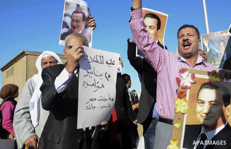 Supporters of former Egyptian President Hosni Mubarak chant slogans as they wait for him to be transferred to a court, in front of the court, in Cairo November 29, 2014. An Egyptian court is due to deliver its verdict on...