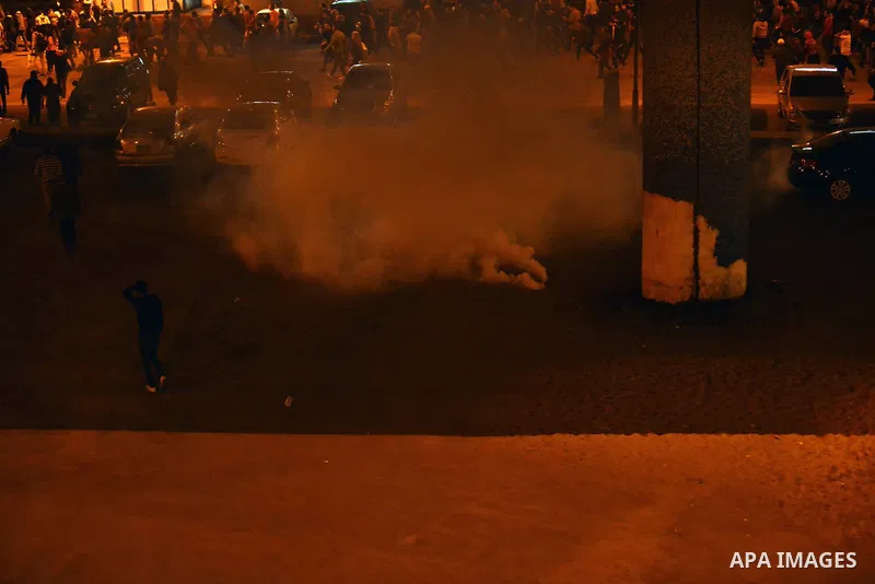 Egyptian anti-Mubarak protesters run for cover from tear gas during clashes with riot police at Abdel Moneim Riad, a main transportation hub for taxis and buses, after hearing the verdict of former Egyptian president Hos...