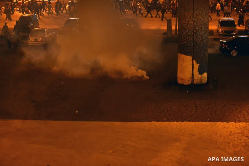 Egyptian anti-Mubarak protesters run for cover from tear gas during clashes with riot police at Abdel Moneim Riad, a main transportation hub for taxis and buses, after hearing the verdict of former Egyptian president Hos...
