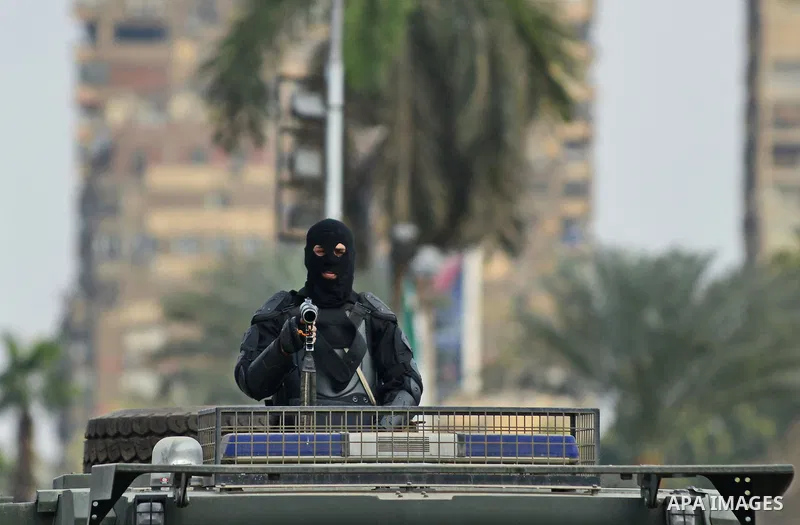 A member of Egyptian security forces stands on an armored vehicle outside the Cairo University , one day after a court dismissed murder charges against former president Hosni Mubarak, Egypt, 30 November 2014. Two people...
