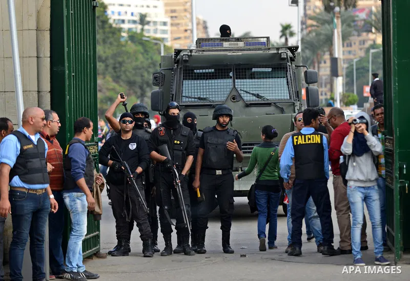 Egyptian policemen stand in front of an armored vehicle outside the Cairo University, one day after a court dismissed murder charges against former president Hosni Mubarak, Egypt, 30 November 2014. Two people were killed...