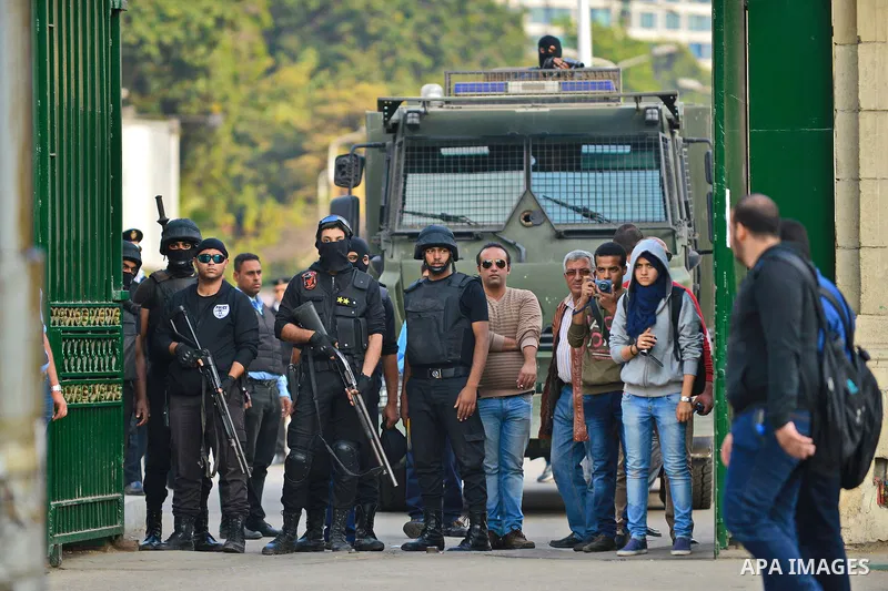 Egyptian policemen stand in front of an armored vehicle outside the Cairo University, one day after a court dismissed murder charges against former president Hosni Mubarak, Egypt, 30 November 2014. Two people were killed...