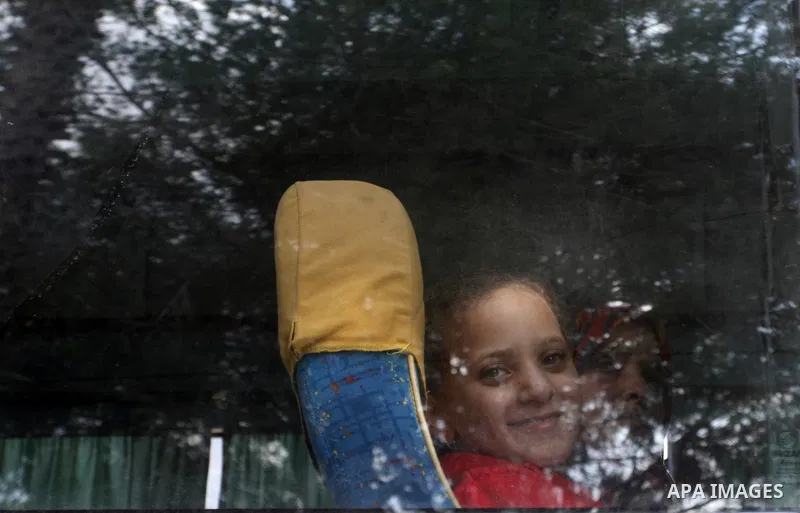 Palestinians look out of a bus window as they return to Gaza at the Rafah border crossing between Egypt and southern Gaza Strip on November 30, 2014. Egyptian authorities reopened this week the Rafah crossing with Gaza f...