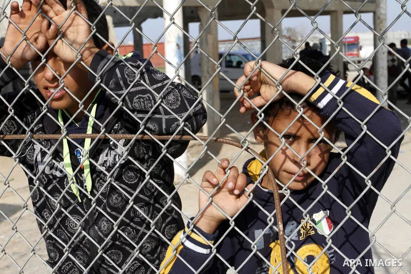 Palestinians look on as they wait their relatives to cross into Gaza through the Rafah border crossing between Egypt and southern Gaza Strip on November 30, 2014. Egyptian authorities reopened this week the Rafah crossin...