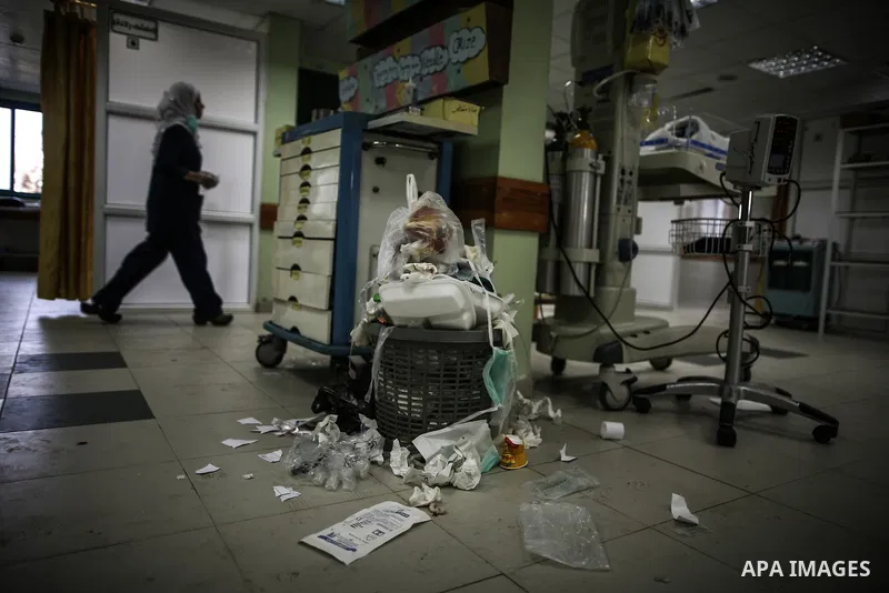 A Palestinian doctor of the former government in Gaza Strip works at al-shifa hospital as clean workers protest to demand for pay their salaries, in Gaza City December 4, 2014. Photo by Ali Jadallah