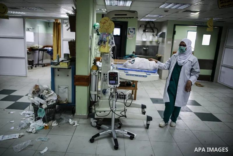 A Palestinian doctor of the former government in Gaza Strip works at al-shifa hospital as clean workers protest to demand for pay their salaries, in Gaza City December 4, 2014. Photo by Ali Jadallah