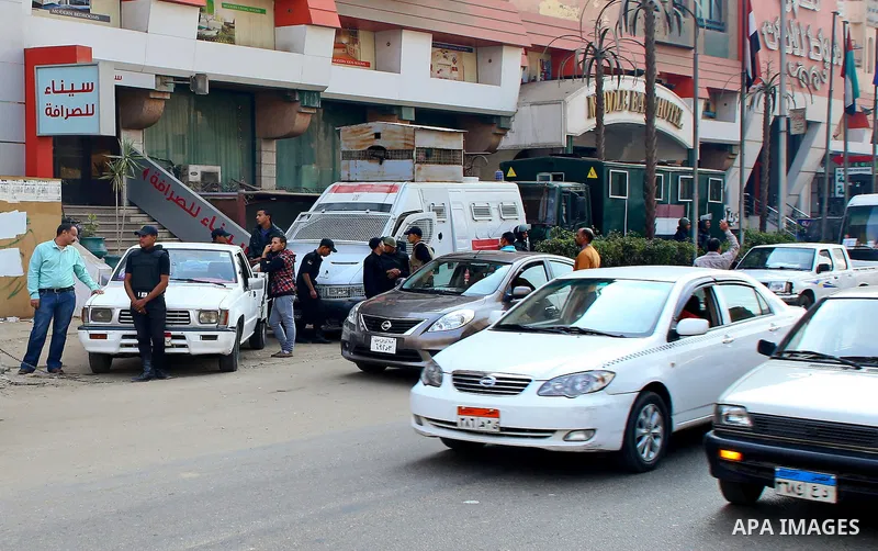 Egyptian police and investigators stand at the scene after defused a bomb in al-Haram street, near Cairo, December 5, 2014. Photo by Amr Sayed