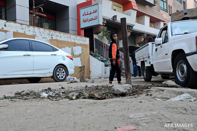 An Egyptian boy stands watch at the scene after defused a bomb by civil protection forces in al-Haram street, near Cairo, December 5, 2014. Photo by Amr Sayed