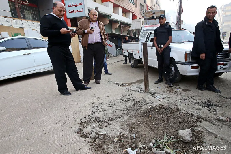 Egyptian police and investigators stand at the scene after defused a bomb in al-Haram street, near Cairo, December 5, 2014. Photo by Amr Sayed