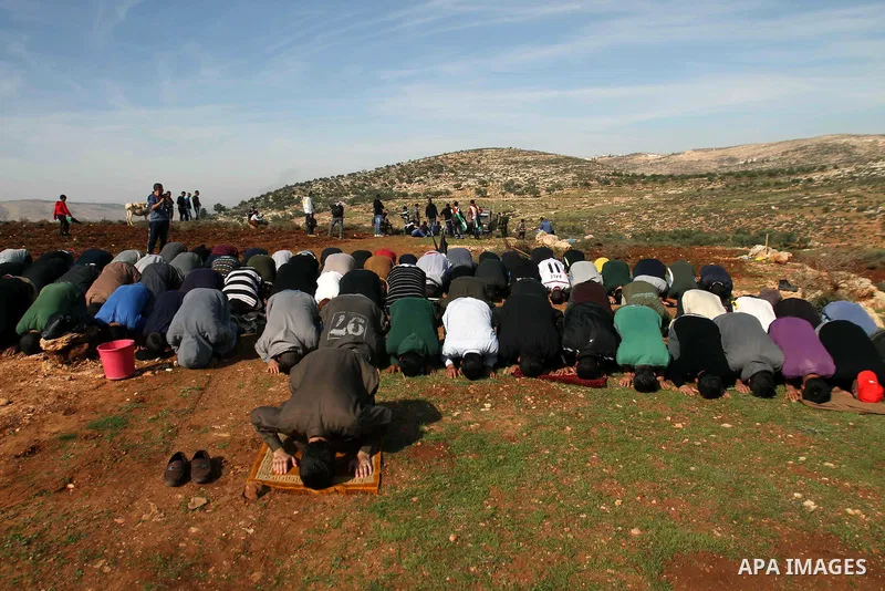 Palestinian farmers pray at their field in Salem village, near the West Bank city of Nablus, December 5, 2014. Many groves are effectively off limits to Palestinians or threatened with expropriation or access is highly r...