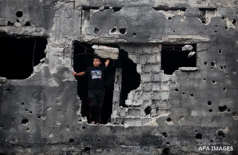 A Palestinian boy stands on the rubbles of his family's house, which was destroyed during the recent Israeli offensive on Gaza Strip, in Shijaiyah neighborhood, east Gaza City, December 8, 2014. According to housing mini...