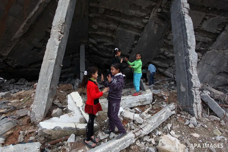 Palestinian children play on the rubbles of a house, which was destroyed during the recent Israeli offensive on Gaza Strip, in Shijaiyah neighborhood, east Gaza City, December 8, 2014. According to housing minister Mufee...