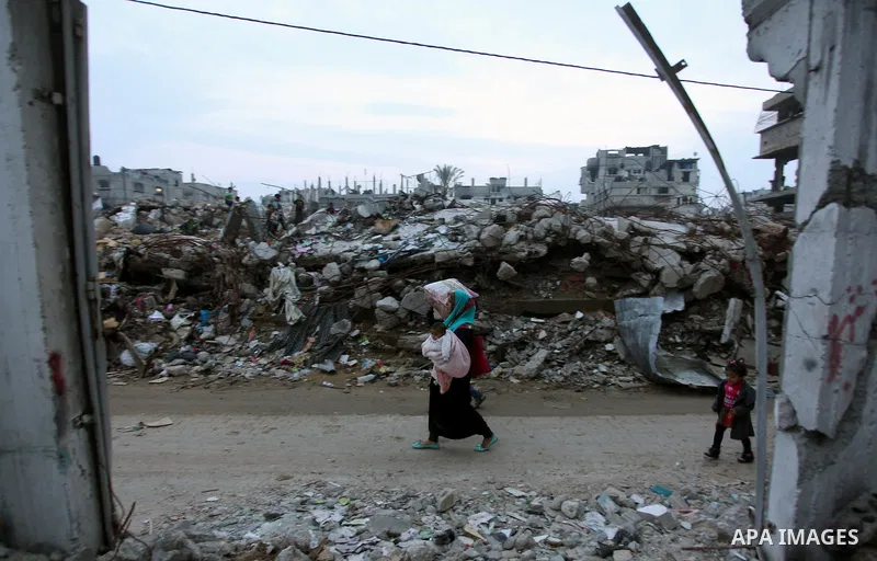 A Palestinian woman walks past the rubbles of houses, which were destroyed during the recent Israeli offensive on Gaza Strip, in Shijaiyah neighborhood, east Gaza City, December 8, 2014. According to housing minister Muf...