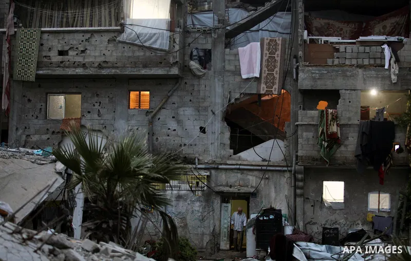 A Palestinian man stands at the entrance of his house, which was destroyed during the recent Israeli offensive on Gaza Strip, in Shijaiyah neighborhood, east Gaza City, December 8, 2014. According to housing minister Muf...