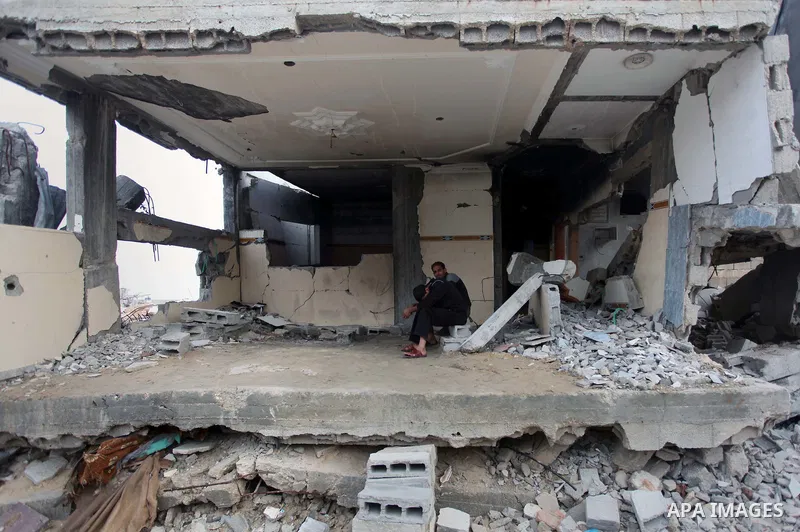 A Palestinian man sits on the rubbles of his house, which was destroyed during the recent Israeli offensive on Gaza Strip, in Shijaiyah neighborhood, east Gaza City, December 8, 2014. According to housing minister Mufeed...