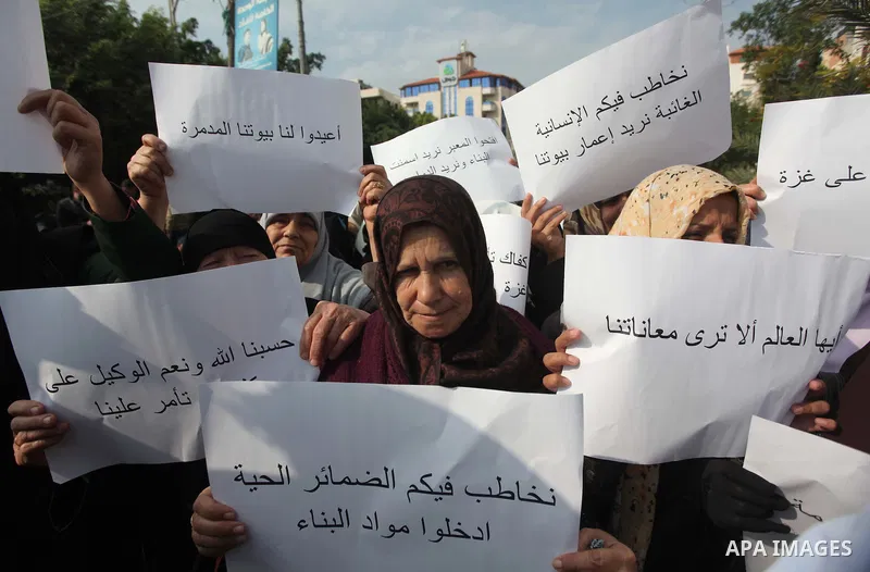 Palestinians gather during a protest against the delay in acquiring building material in front of the headquarters of the Council of Ministers in Gaza city December 9, 2014. According to housing minister Mufeed al-Hasayn...