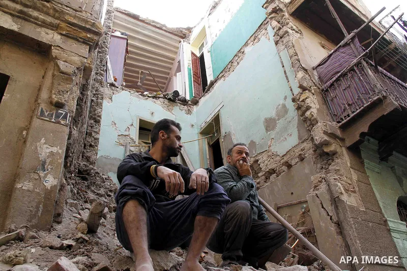 Egyptians and rescue workers inspect the site of a collapsed two-storey building in the Cairo district of Torgoman, December 9, 2014. The Ministry of Health and Population of Egypt injuring two people in the collapse of...