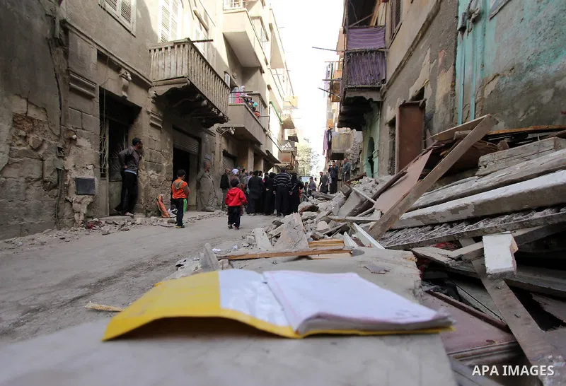 Egyptians and rescue workers inspect the site of a collapsed two-storey building in the Cairo district of Torgoman, December 9, 2014. The Ministry of Health and Population of Egypt injuring two people in the collapse of...
