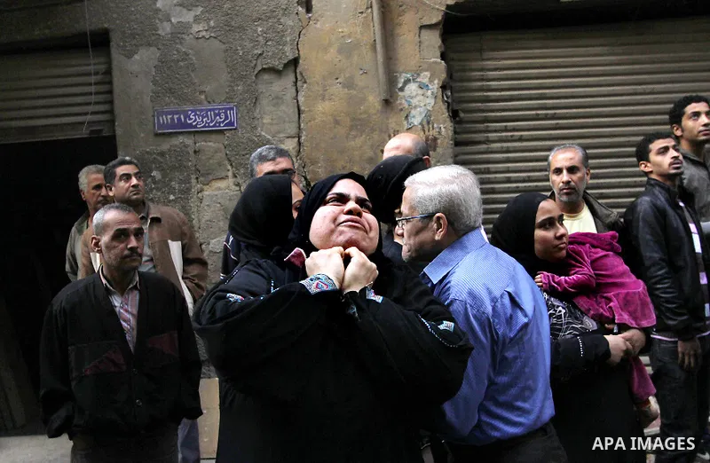 Egyptians and rescue workers inspect the site of a collapsed two-storey building in the Cairo district of Torgoman, December 9, 2014. The Ministry of Health and Population of Egypt injuring two people in the collapse of...