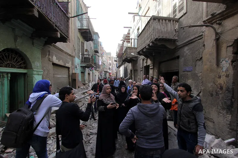 Egyptians and rescue workers inspect the site of a collapsed two-storey building in the Cairo district of Torgoman, December 9, 2014. The Ministry of Health and Population of Egypt injuring two people in the collapse of...