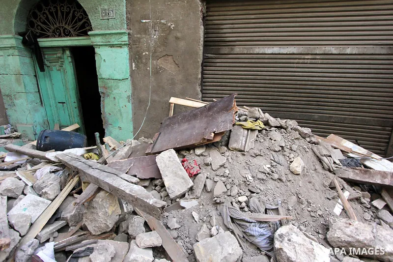 Egyptians and rescue workers inspect the site of a collapsed two-storey building in the Cairo district of Torgoman, December 9, 2014. The Ministry of Health and Population of Egypt injuring two people in the collapse of...