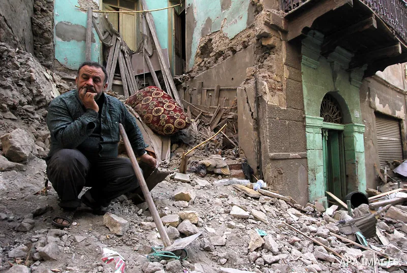 Egyptians and rescue workers inspect the site of a collapsed two-storey building in the Cairo district of Torgoman, December 9, 2014. The Ministry of Health and Population of Egypt injuring two people in the collapse of...