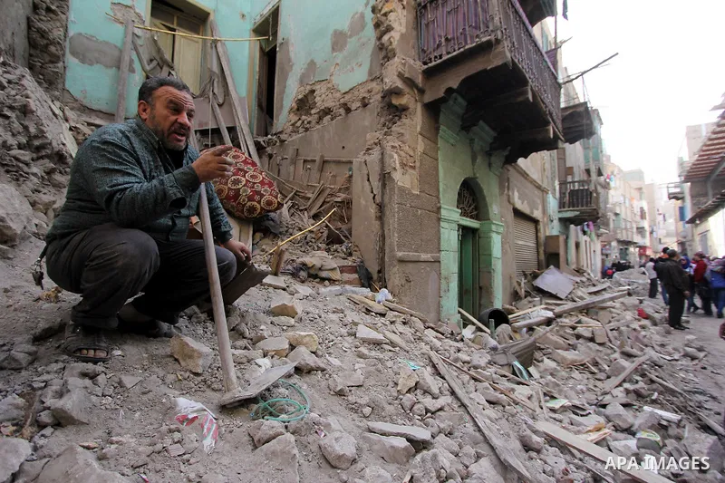 Egyptians and rescue workers inspect the site of a collapsed two-storey building in the Cairo district of Torgoman, December 9, 2014. The Ministry of Health and Population of Egypt injuring two people in the collapse of...