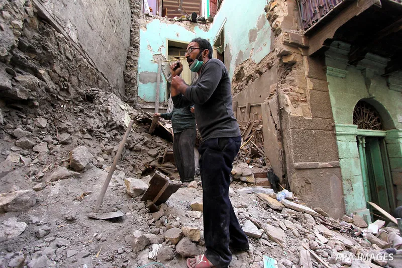 Egyptians and rescue workers inspect the site of a collapsed two-storey building in the Cairo district of Torgoman, December 9, 2014. The Ministry of Health and Population of Egypt injuring two people in the collapse of...