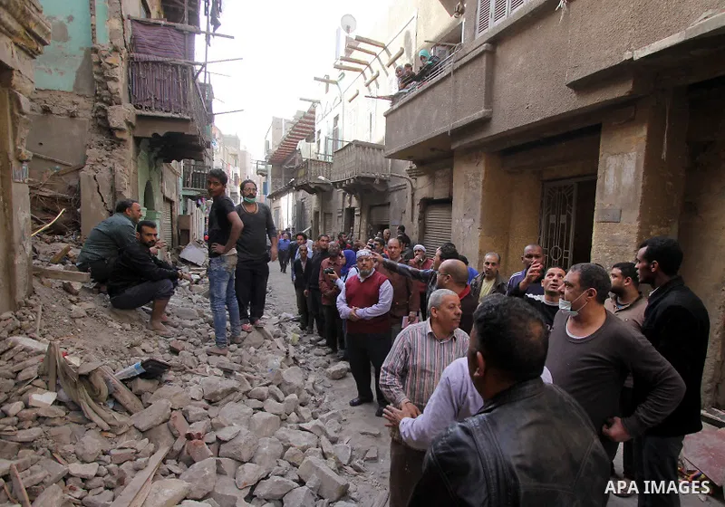 Egyptians and rescue workers inspect the site of a collapsed two-storey building in the Cairo district of Torgoman, December 9, 2014. The Ministry of Health and Population of Egypt injuring two people in the collapse of...