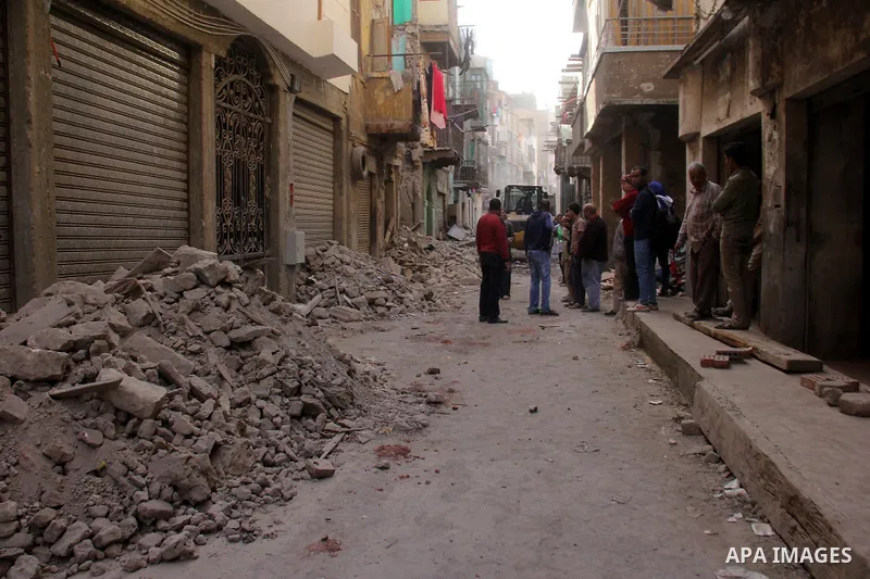Egyptians and rescue workers inspect the site of a collapsed two-storey building in the Cairo district of Torgoman, December 9, 2014. The Ministry of Health and Population of Egypt injuring two people in the collapse of...