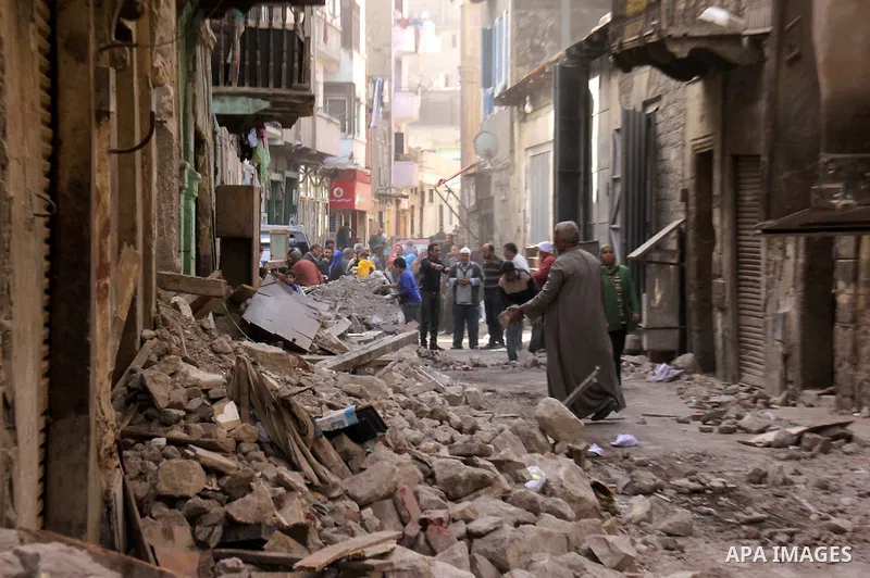 Egyptians and rescue workers inspect the site of a collapsed two-storey building in the Cairo district of Torgoman, December 9, 2014. The Ministry of Health and Population of Egypt injuring two people in the collapse of...
