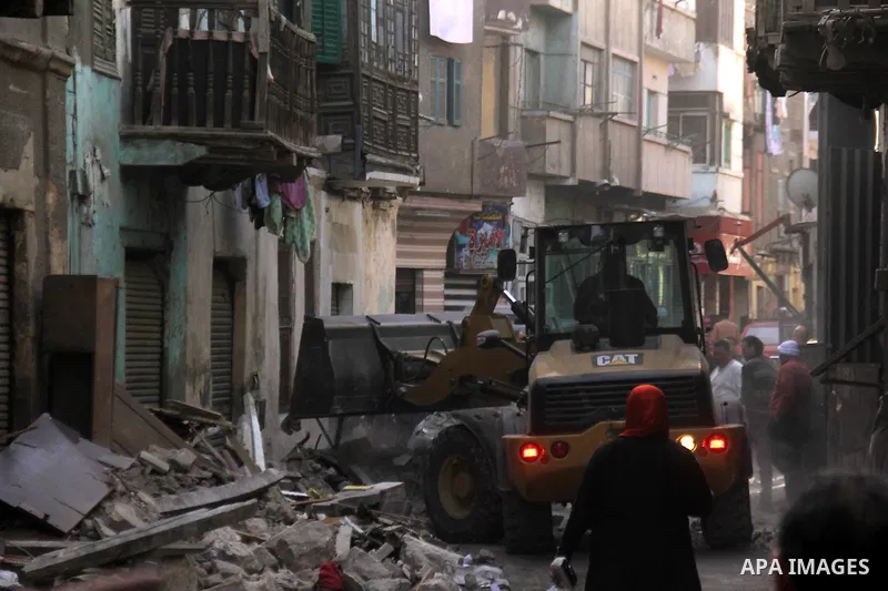 Egyptians and rescue workers inspect the site of a collapsed two-storey building in the Cairo district of Torgoman, December 9, 2014. The Ministry of Health and Population of Egypt injuring two people in the collapse of...